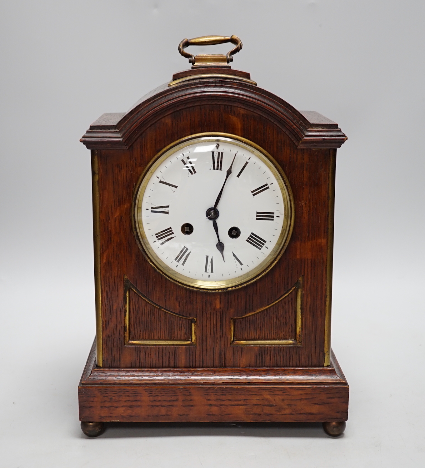 A oak mantel clock in a Regency style with pad top, striking on a coiled gong, 30cm high